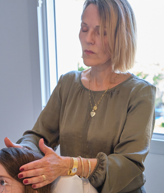 Rose pratique le magnétisme sur le crâne d'un client à Auray